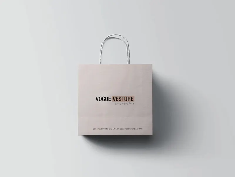 Minimal blush Vogue Vesture paper shopping bag shown against a light grey background.