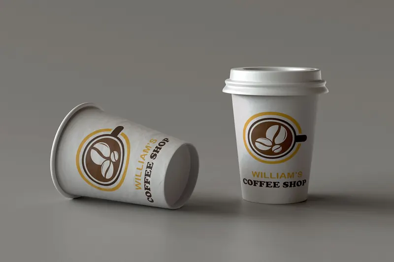 Two William's Coffee Shop paper cups showing the brown and gold circular coffee logo.